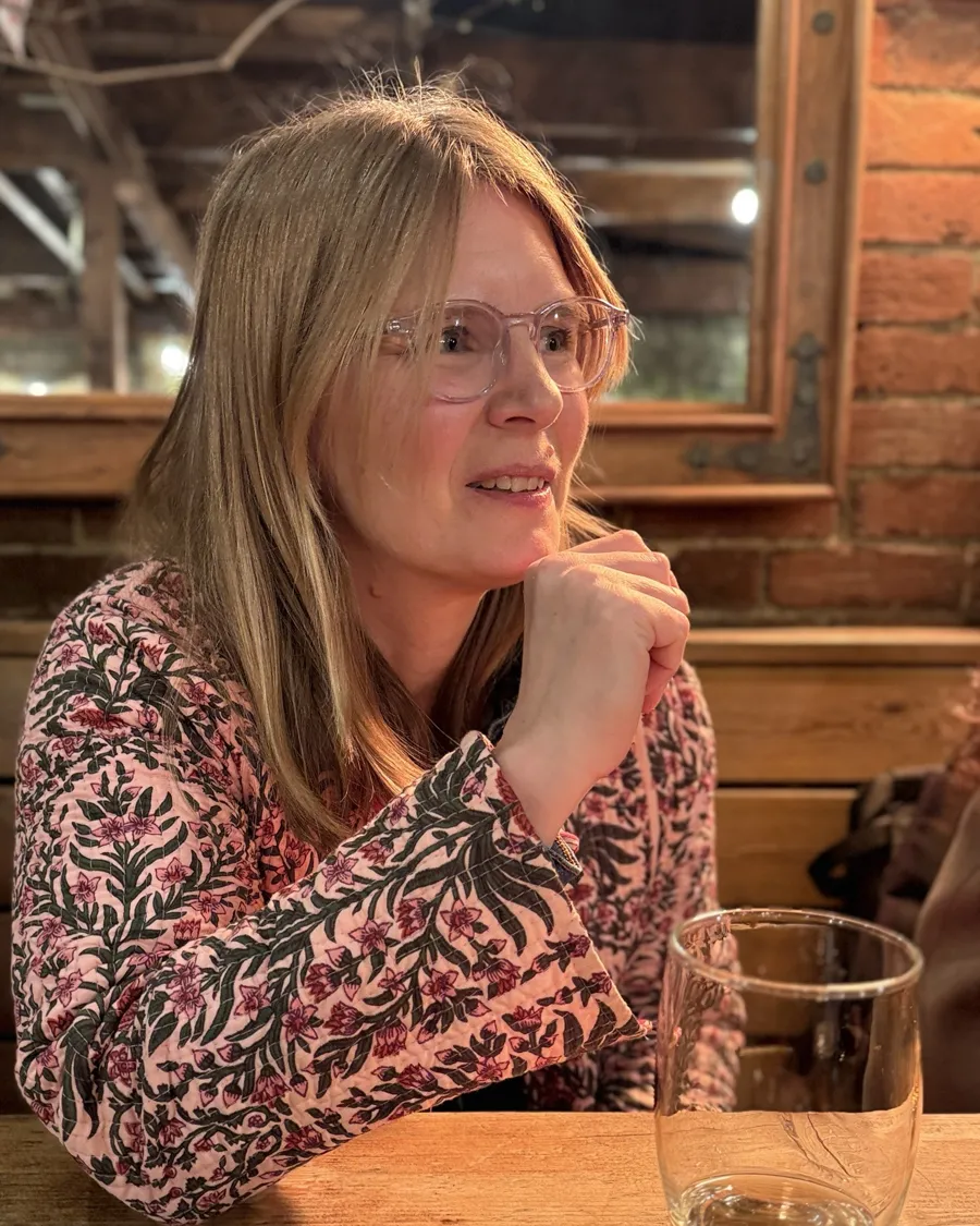 Ruth listening and smiling across a wooden table