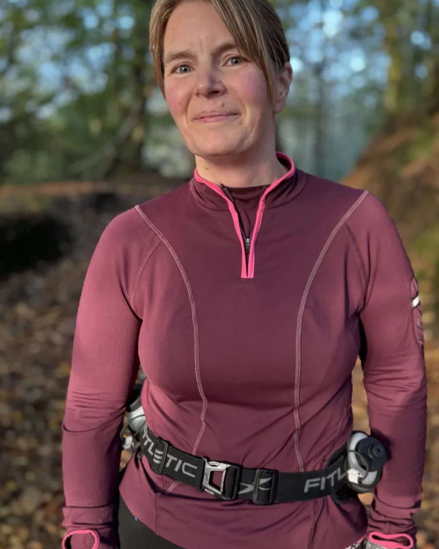 Ruth Blanco smiling on a woodland path in autumn light